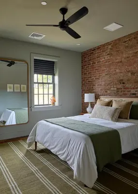 a bedroom with a large bed and a brick wall at Eleanor Inn - Suite Lorena in Warwick