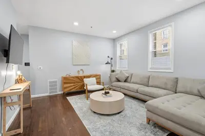 a living room with a couch and a table at Spacious 3BR 2BA Apt with Private Parking Walk to PATH in Jersey City
