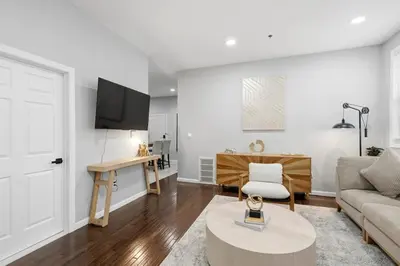 a living room with a couch and a table at Spacious 3BR 2BA Apt with Private Parking Walk to PATH in Jersey City