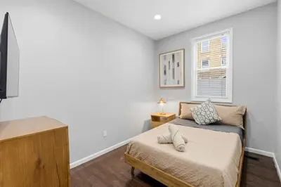a bedroom with a bed and a window at Spacious 3BR 2BA Apt with Private Parking Walk to PATH in Jersey City
