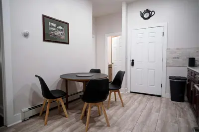 a dining room with a table and black chairs at Stylish & Comfortable City Stay in West New York