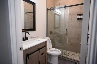 a bathroom with a toilet and a sink and a shower at Stylish & Comfortable City Stay in West New York