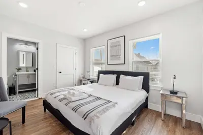 a bedroom with a large bed and two windows at Premier 3BR-5BD-3Bath Retreat with NYC Access in Jersey City