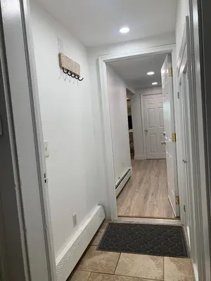 a hallway with a door leading into a room at 2 Bedroom Garden Apartment Near Journal Square - Prime World Cup Lodging in Jersey City