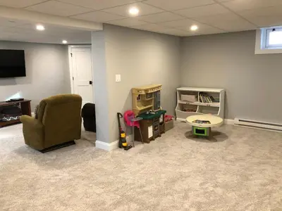 a living room with a couch and a chair and a tv at Comfortable Craftsman Getaway in Lancaster
