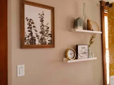 a wall with shelves and a picture and a clock at Comfortable Craftsman Getaway in Lancaster