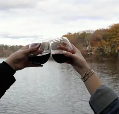 two people holding glasses of wine in front of a lake at Couples Lakefront Retreat in the Poconos in Saylorsburg