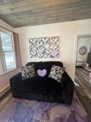a black couch with pillows in a living room at Couples Lakefront Retreat in the Poconos in Saylorsburg