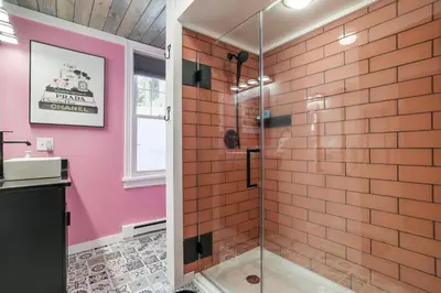 a bathroom with a glass shower with pink walls at Couples Lakefront Retreat in the Poconos in Saylorsburg