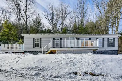 a white house with a porch in the snow at Hike and Explore! Nature-Centric Hudson Valley Home in Napanoch