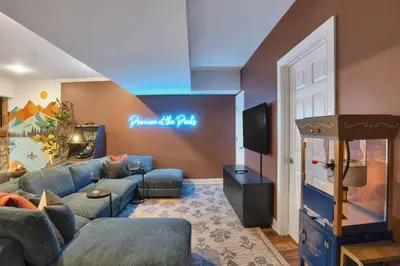 a living room with a couch and a video game at Lux Camelback Summit: 5br, Hot Tub, Game Room in Tannersville