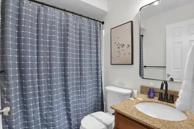 a bathroom with a sink and a blue shower curtain at Lux Camelback Summit: 5br, Hot Tub, Game Room in Tannersville