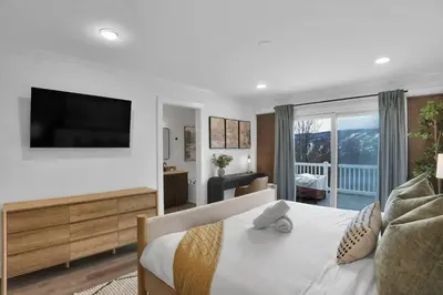 a bedroom with a bed with a television on a wall at Lux Camelback Summit: 5br, Hot Tub, Game Room in Tannersville