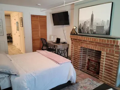 a bedroom with a bed and a fireplace with a television at The Cozy Flat near the Apple in Jersey City