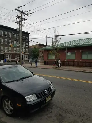 a black car parked on the side of a street at The Cozy Flat near the Apple in Jersey City