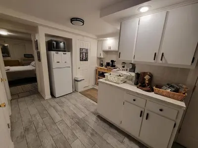 a kitchen with white cabinets and a white refrigerator at The Cozy Flat near the Apple in Jersey City