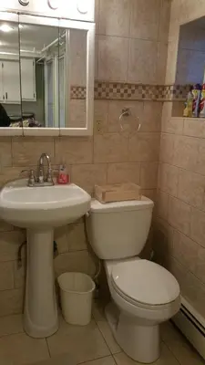 a bathroom with a toilet and a sink at The Cozy Flat near the Apple in Jersey City