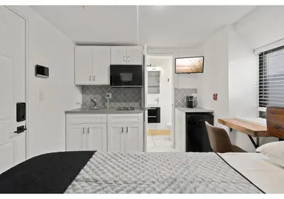 a white bedroom with a bed and a kitchen at Fairmount Park GSN Soil 2 in Philadelphia