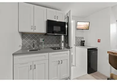 a kitchen with white cabinets and a black refrigerator at Fairmount Park GSN Soil 2 in Philadelphia