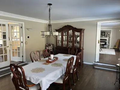 a dining room with a table and a chandelier at Luxury Private Estate, 5BR 6BA, close to MetLife with ample parking in Green Village
