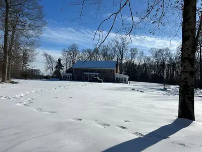 a building in the snow with footprints in the snow at Luxury Private Estate, 5BR 6BA, close to MetLife with ample parking in Green Village