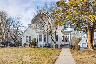 a white house with a red wreath on the door at Explore Orange and NYC! Luxury Family Home with Deck in Orange