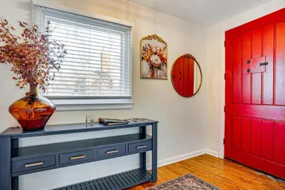 a vase on a table next to a red door at Explore Orange and NYC! Luxury Family Home with Deck in Orange