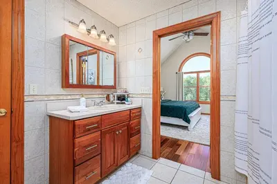 a bathroom with a sink and a mirror and a bed at Blissful Mountain Getaway