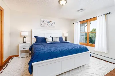 a white bedroom with a bed and a window at Blissful Mountain Getaway
