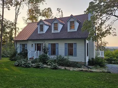 a white house with a brown roof on a yard at Fernwood Vista in Strasburg