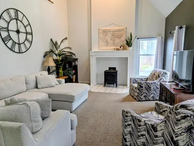 a living room with a couch and a clock on the wall at Fernwood Vista in Strasburg