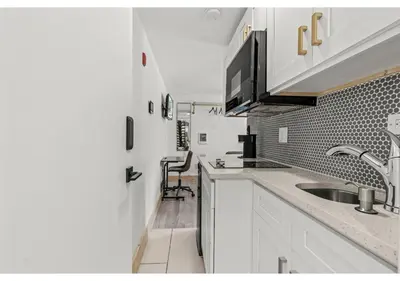 a white kitchen with a sink and a counter at Temple Town GSN Soil 3 in Philadelphia