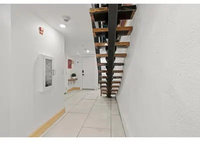 a hallway with white walls and wooden stairs at Temple Town GSN Soil 3 in Philadelphia