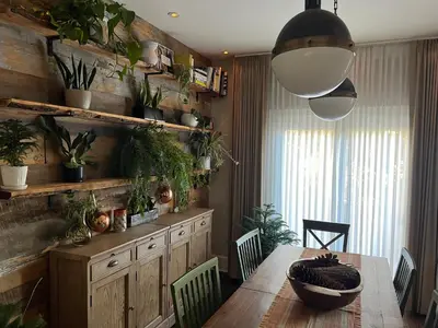 a dining room with a table and some plants at Stylish Mission-Style Home on Park in Jersey City, NJ in Jersey City
