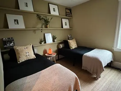 a room with two beds and a couch and a chair at Stylish Mission-Style Home on Park in Jersey City, NJ in Jersey City