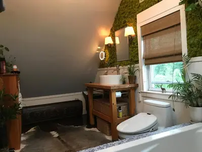 a bathroom with a toilet and a sink with plants at Stylish Mission-Style Home on Park in Jersey City, NJ in Jersey City