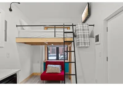 a room with a bunk bed and a red chair at City Ave GSN Vine 1 in Philadelphia