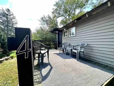 a patio with a table and chairs on the side of a house at Boyertown Bungalow Near the Manatawny Creek in Boyertown