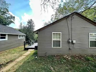 a house with a porch next to a yard at Boyertown Bungalow Near the Manatawny Creek in Boyertown