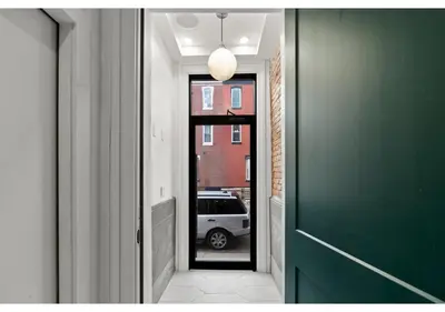 a hallway with a green door and a car outside at Center City GSN Vine 2 in Philadelphia