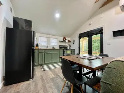 a kitchen with a table and a black refrigerator at Fir Lane Lodge Near the Manatawny Creek in Boyertown