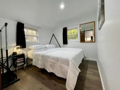 a white bedroom with a bed and a mirror at Fir Lane Lodge Near the Manatawny Creek in Boyertown