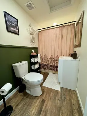 a bathroom with a white toilet and a shower at Manatawny Creek Cottage in Boyertown
