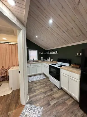 a kitchen with white cabinets and a stove top oven at Manatawny Creek Cottage in Boyertown