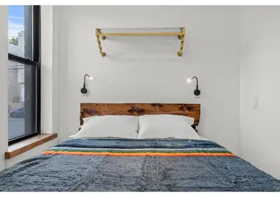 a bedroom with a bed with a wooden headboard and a window at Northern Liberties GSN Vine 3 in Philadelphia