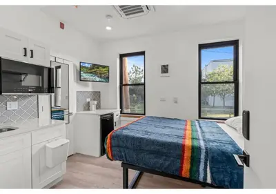 a white bedroom with a bed and a kitchen at Northern Liberties GSN Vine 3 in Philadelphia