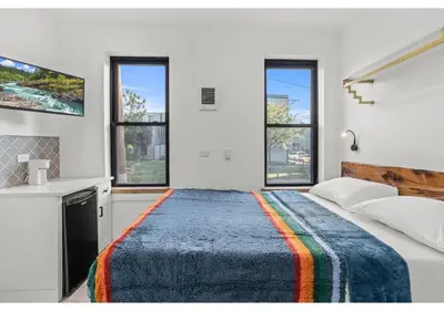 a bedroom with a large bed and two windows at Northern Liberties GSN Vine 3 in Philadelphia