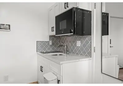 a kitchen with white cabinets and a sink at Northern Liberties GSN Vine 3 in Philadelphia