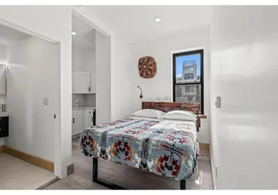 a white bedroom with a bed and a kitchen at Temple University GSN Vine 4 in Philadelphia