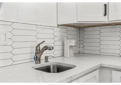 a kitchen counter with a sink and white cabinets at Temple University GSN Vine 4 in Philadelphia